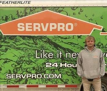 Photo of male SERVPRO of Spencer & Iowa Great Lakes Production Crew Member Tanner Wallace standing next to company trailer.