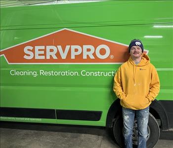 SERVPRO employee in front of a green van.