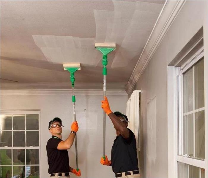 SERVPRO technicians cleaning soot off of ceilings. 